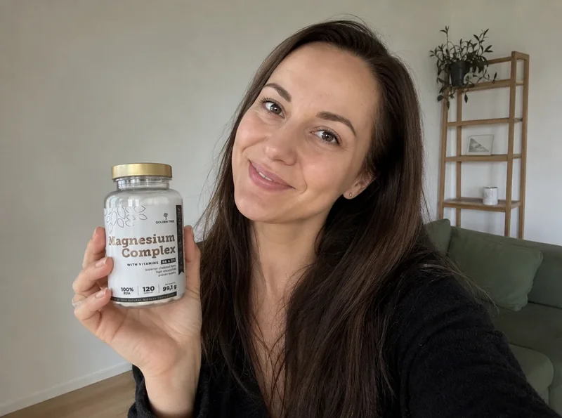 Young woman at home holding supplement bottle