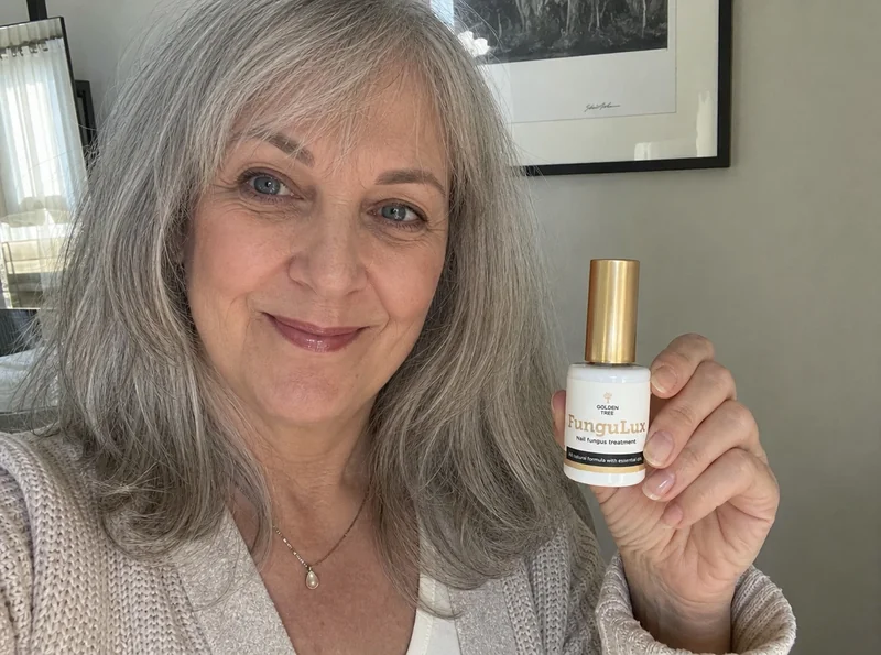 Woman 61 holding FunguLux bottle at home