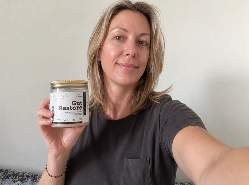 Woman holding gut supplement product selfie