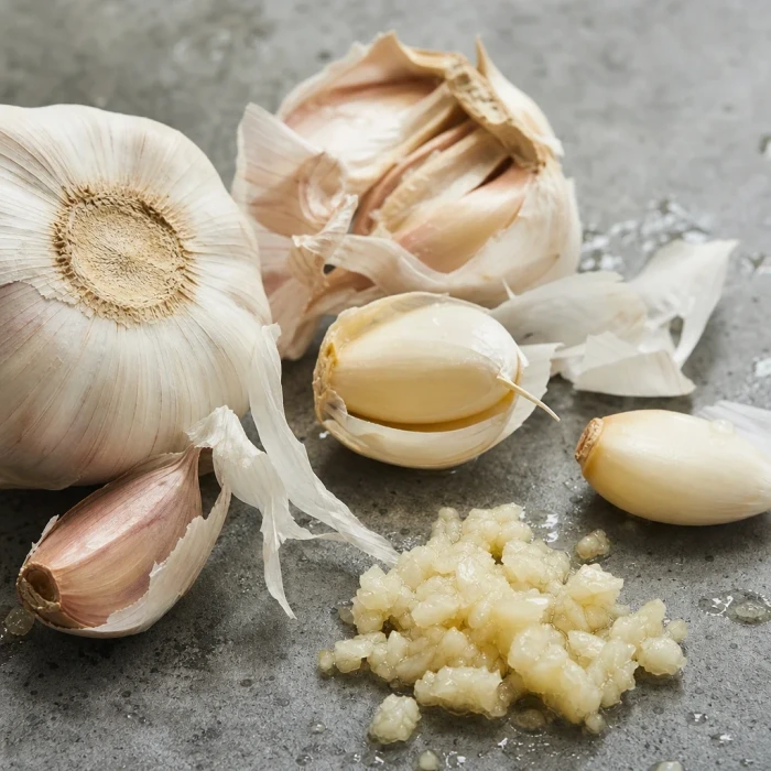 Garlic cloves and plant matter on stone
