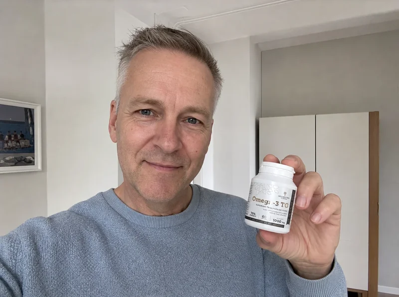 Middle-aged man holding Omega 3 product